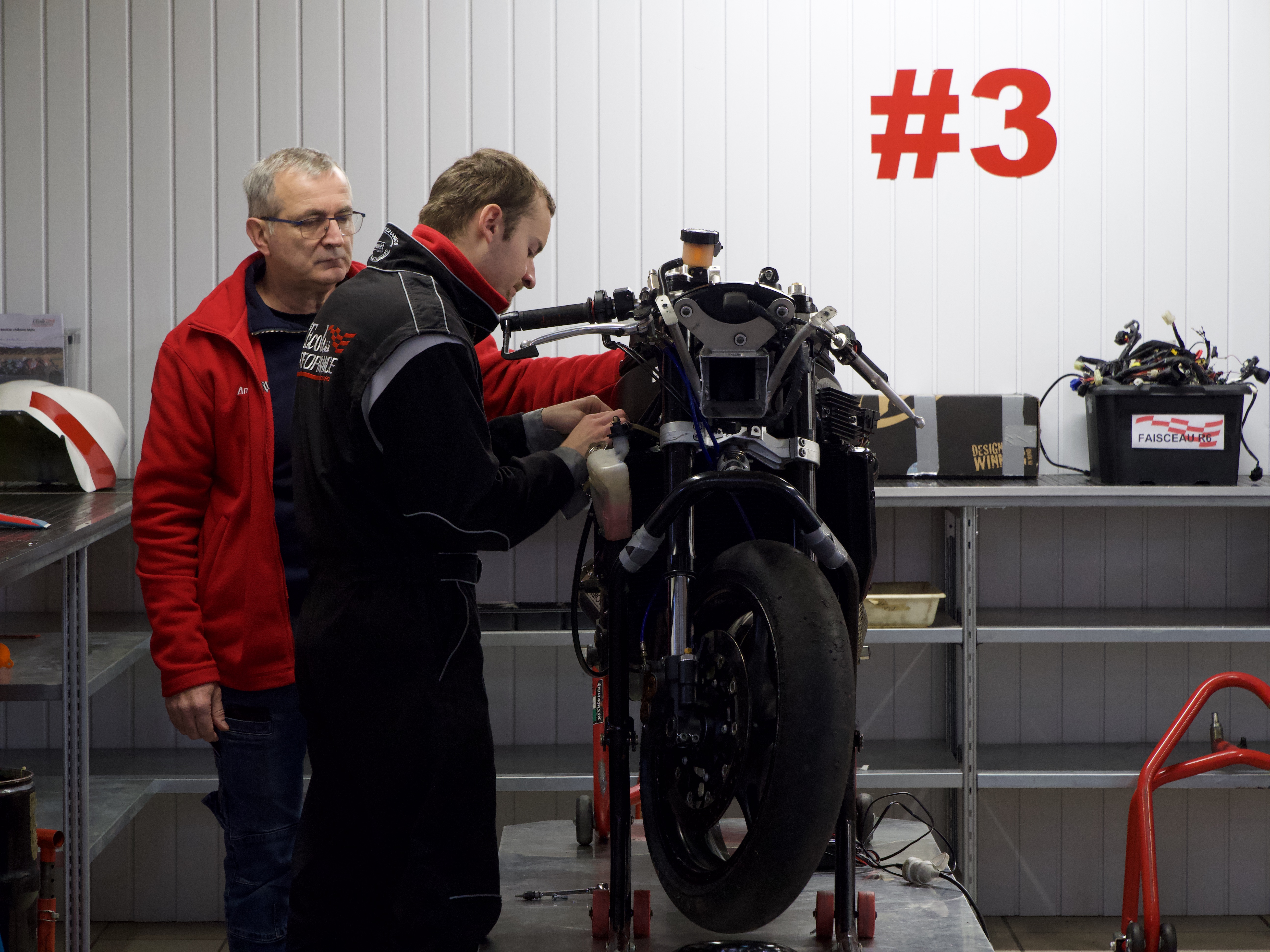 Prise de pression des pneus d'une moto par des techniciens de la compétition moto sur le circuit de Nogaro