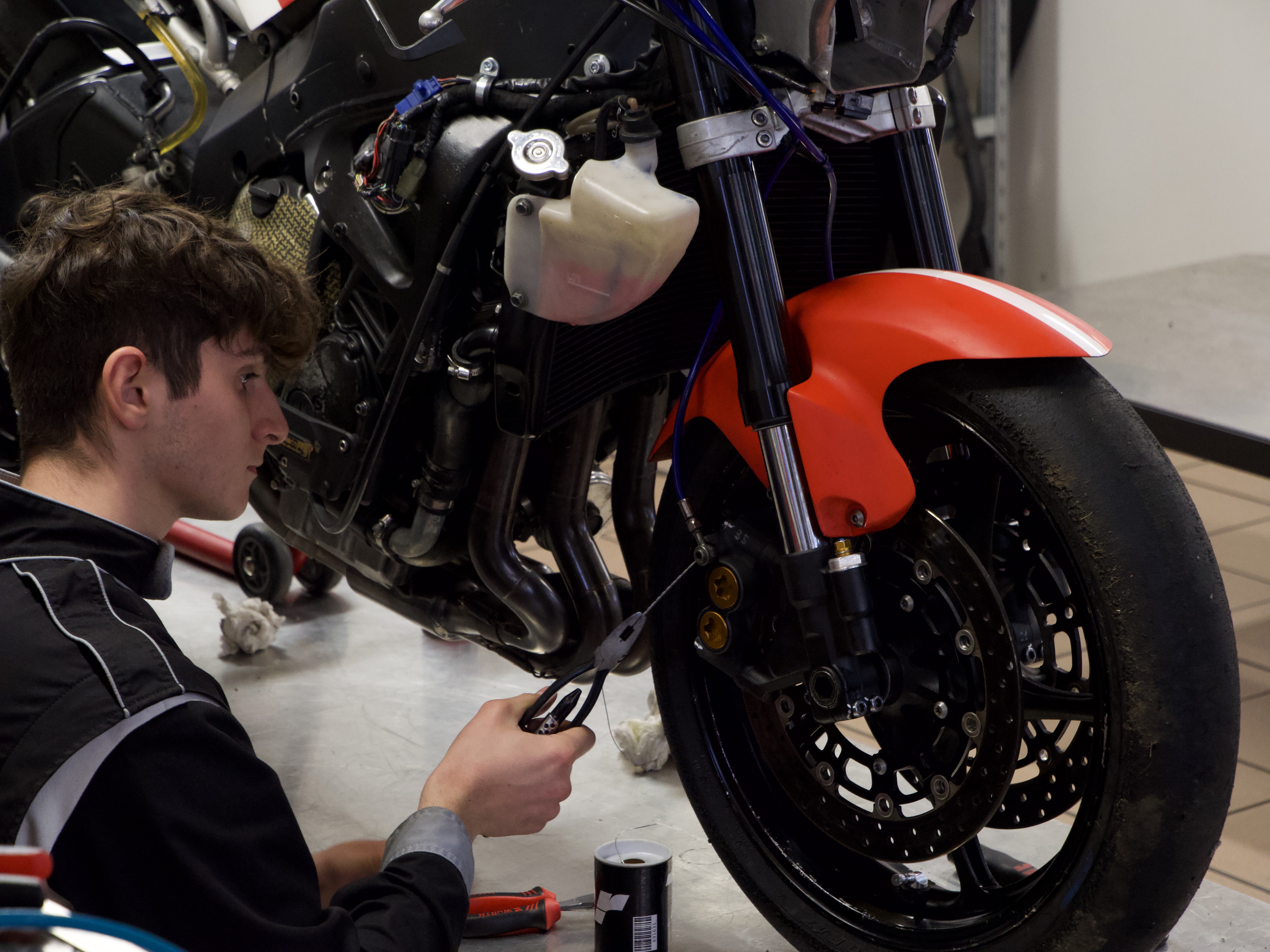 Prise de pression des pneus d'une moto par des techniciens de la compétition moto sur le circuit de Nogaro